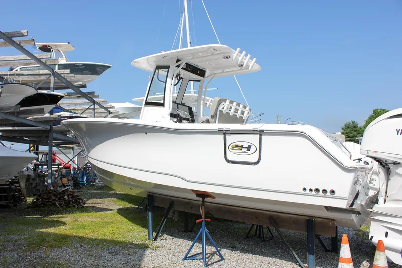 Slide: The Image of 2025 Sea Hunt Gamefish 27 boat with Yamaha engine, displayed at marina. - 4