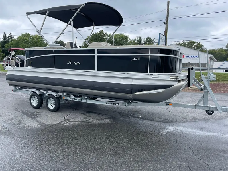 Slide: The Image of 2024 Barletta ARIA 22QC pontoon boat on trailer, black exterior, parked outdoors. - 11