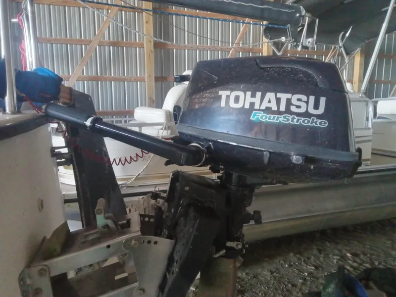 Slide: The Image of Tohatsu FourStroke outboard motor on a Precision 21 sailboat, 1988 model, in a storage shed. - 3