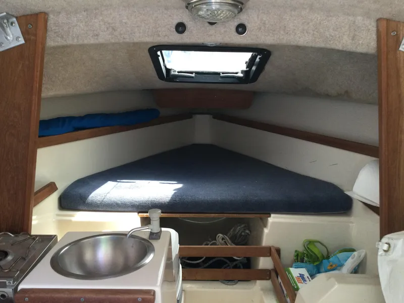Slide: The Image of Interior of a 1988 Precision 21 sailboat cabin with a bed and sink. - 4