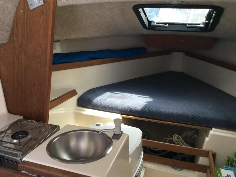Slide: The Image of 1988 Precision 21 sailboat interior with compact kitchenette and cozy sleeping area. - 5