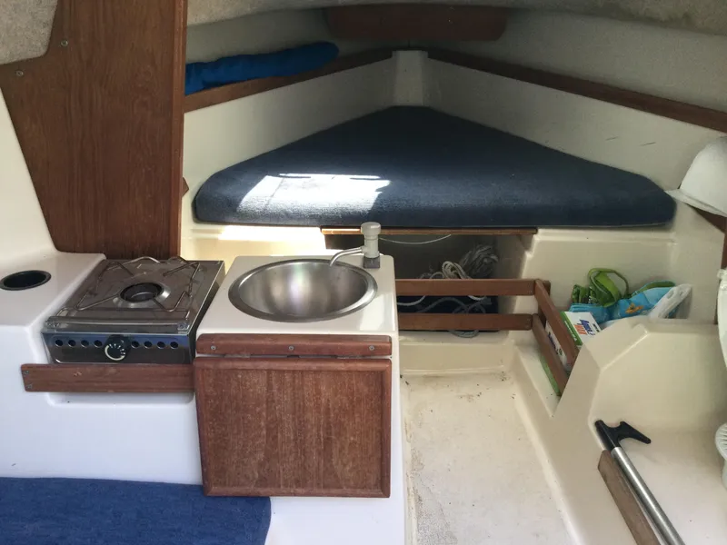 Slide: The Image of 1988 Precision 21 sailboat interior with compact kitchen and sleeping area. - 6