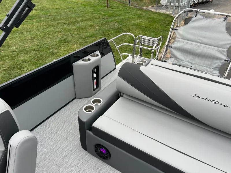 Slide: The Image of 2025 South Bay S224 UL pontoon boat interior with gray seating and cup holders. - 12