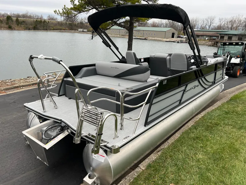 Slide: The Image of 2025 South Bay S224 UL pontoon boat docked by a lakeside. - 4