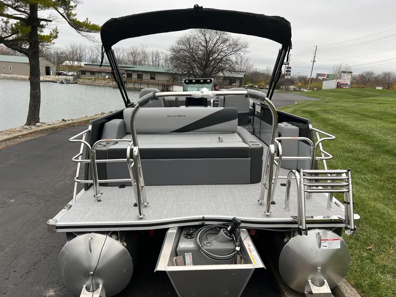 Slide: The Image of 2025 South Bay S224 UL pontoon boat with sleek design, docked near a serene lakeside. - 5