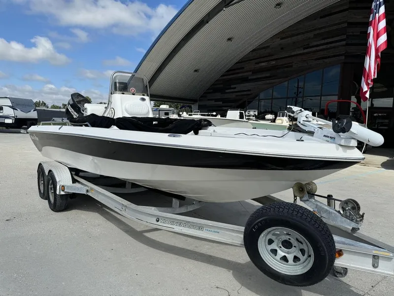 Slide: The Image of 2008 NauticStar 2200 Nauticbay boat on trailer, parked outdoors under a curved roof. - 10