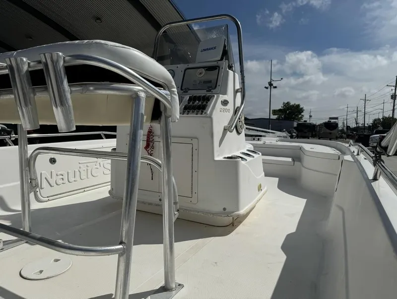 Slide: The Image of 2008 NauticStar 2200 Nauticbay boat interior with console and seating under blue sky. - 16