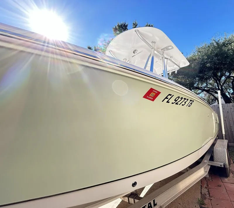 Slide: The Image of 2022 Sea Hunt Ultra 234 boat on trailer under bright sun. - 12