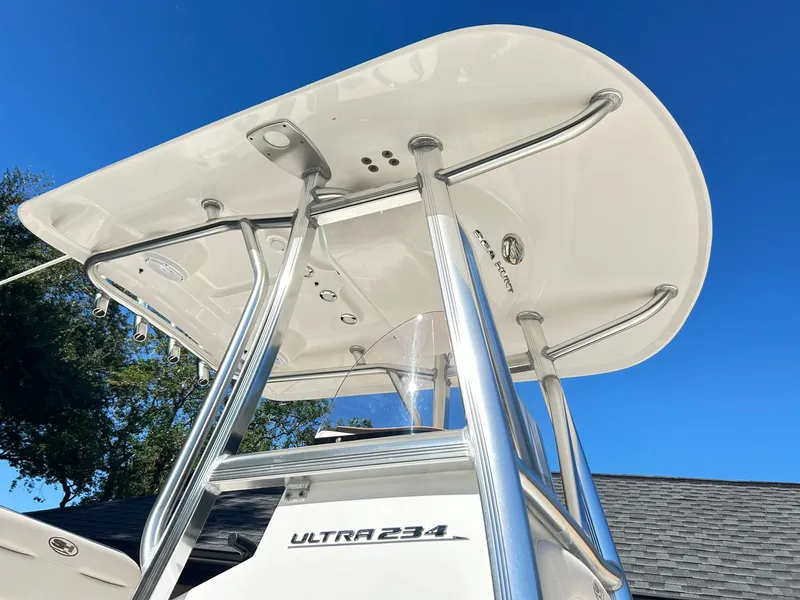 Slide: The Image of 2022 Sea Hunt Ultra 234 boat with T-top against clear blue sky. - 13