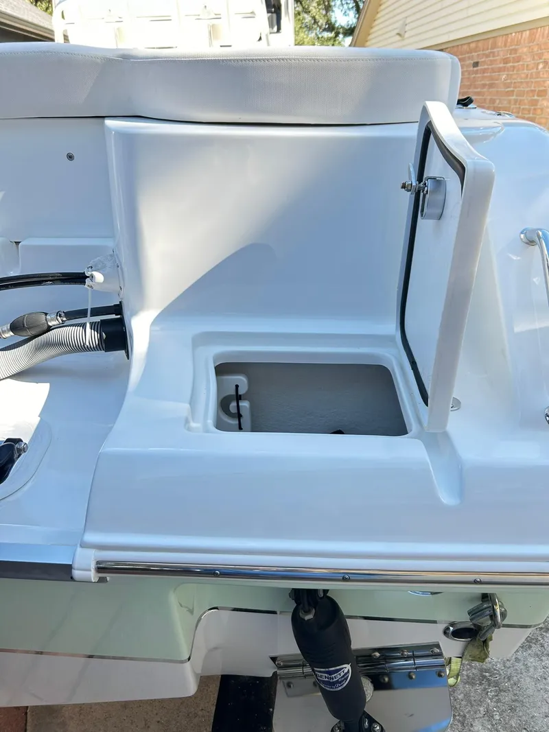 Slide: The Image of 2022 Sea Hunt Ultra 234 boat storage compartment with open hatch, showcasing interior space. - 16