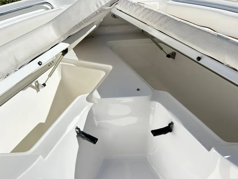 Slide: The Image of 2022 Sea Hunt Ultra 234 boat interior with open storage compartments. - 19