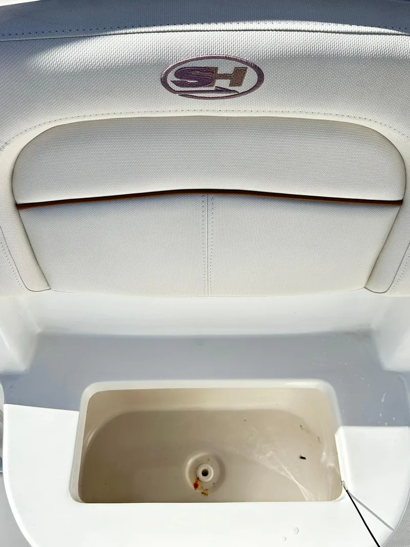 Slide: The Image of 2022 Sea Hunt Ultra 234 boat interior with storage compartment and cushioned seating. - 24