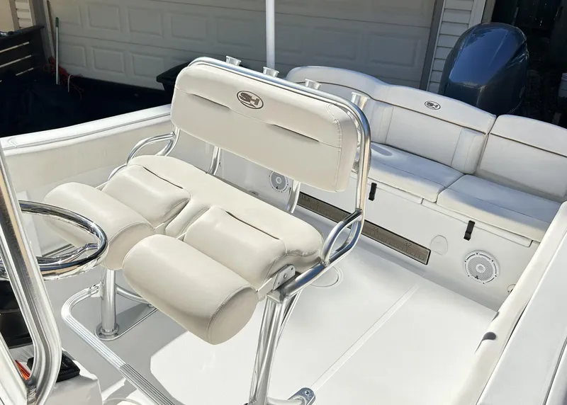 Slide: The Image of 2022 Sea Hunt Ultra 234 boat interior with white seating and steering wheel. - 28