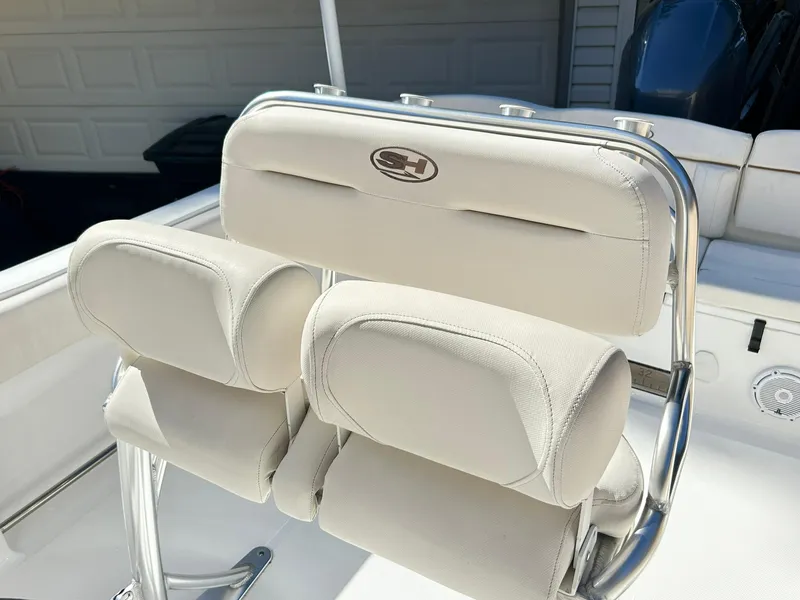 Slide: The Image of 2022 Sea Hunt Ultra 234 boat seating with white cushioned seats and stainless steel frame. - 32