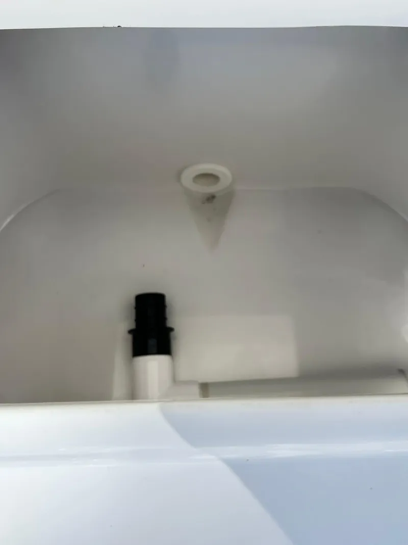 Slide: The Image of 2022 Sea Hunt Ultra 234 boat compartment with drain and pipe fitting. - 36