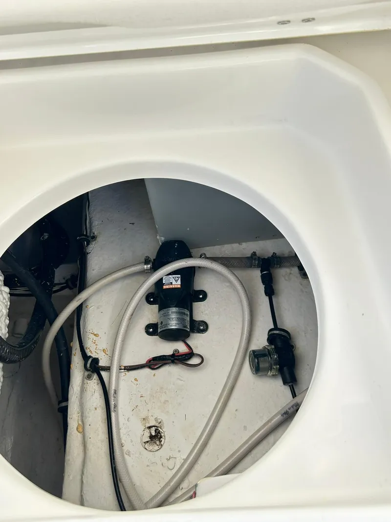Slide: The Image of 2022 Sea Hunt Ultra 234 boat compartment with pump and wiring. - 37