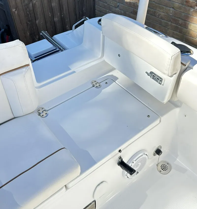 Slide: The Image of 2022 Sea Hunt Ultra 234 boat interior with white seating and storage compartments. - 38