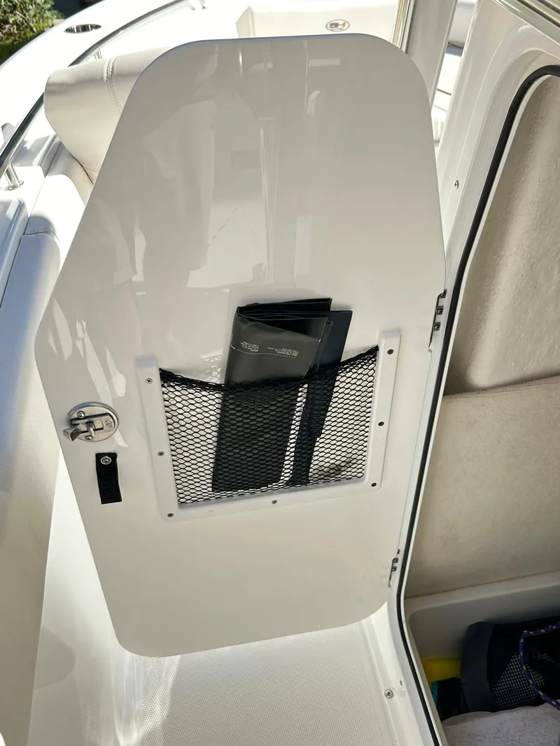 Slide: The Image of 2022 Sea Hunt Ultra 234 boat interior with storage compartment and netted pocket. - 43