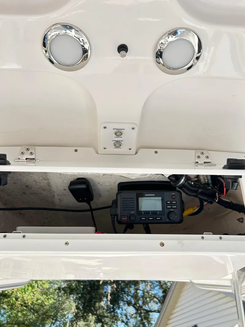 Slide: The Image of 2022 Sea Hunt Ultra 234 boat console with electronic equipment and storage compartment. - 45