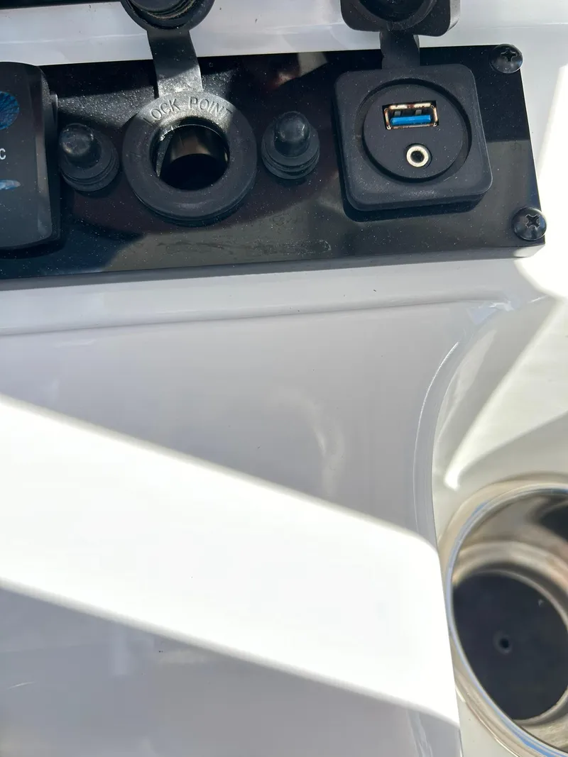 Slide: The Image of Close-up of a 2022 Sea Hunt Ultra 234 boat dashboard with USB and power ports. - 49