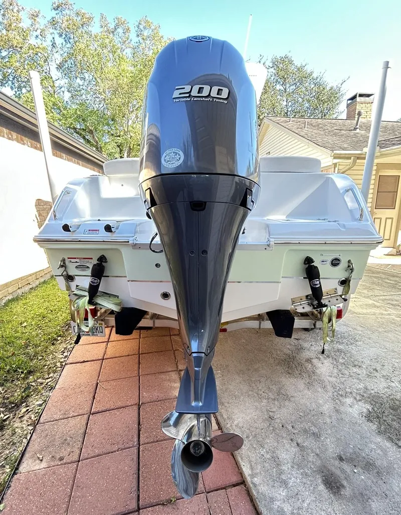 Slide: The Image of 2022 Sea Hunt Ultra 234 boat with 200 horsepower engine, parked on a brick driveway. - 7