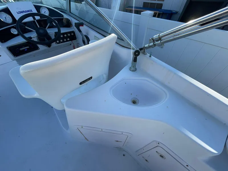 Slide: The Image of 2001 Hurricane 232 OB boat interior with steering wheel and sink. - 12