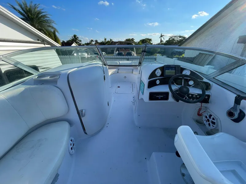 Slide: The Image of 2001 Hurricane 232 OB boat interior with steering wheel and seating under clear blue sky. - 15