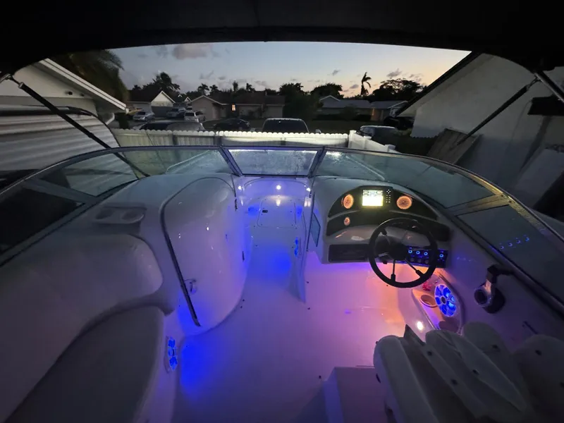 Slide: The Image of 2001 Hurricane 232 OB boat interior with illuminated dashboard and seating at dusk. - 16