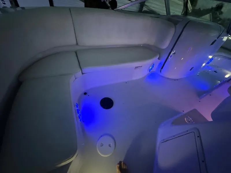 Slide: The Image of 2001 Hurricane 232 OB boat interior with blue LED lighting and cushioned seating. - 28