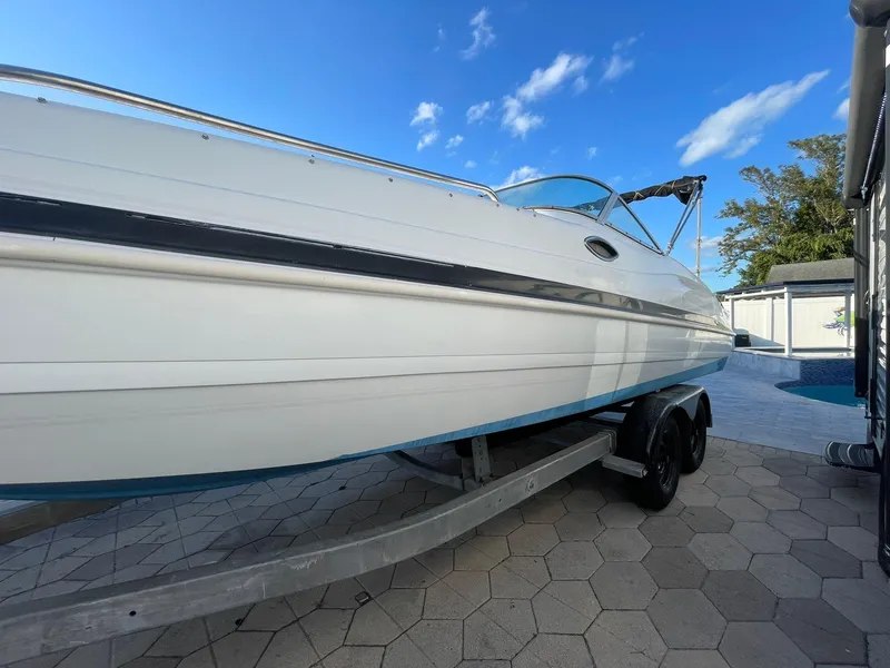 Slide: The Image of 2001 Hurricane 232 OB boat on trailer, parked outdoors under blue sky. - 3