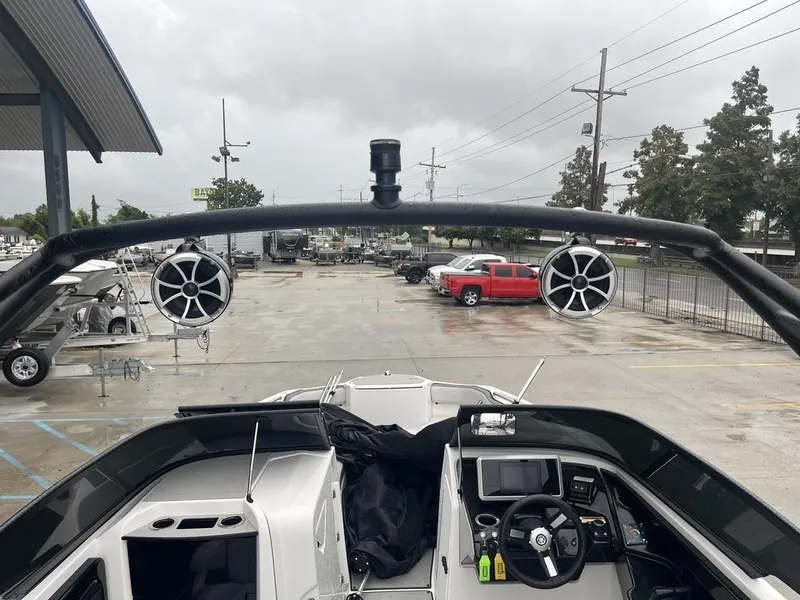 Slide: The Image of 2023 Yamaha AR250 boat interior with speakers and dashboard, parked outdoors. - 10