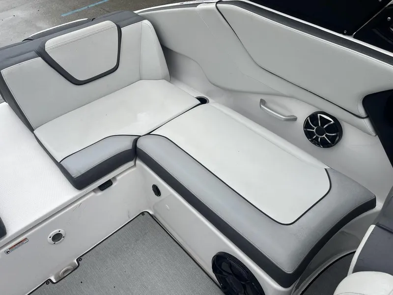 Slide: The Image of 2023 Yamaha AR250 boat interior with white and gray seating and speaker. - 15