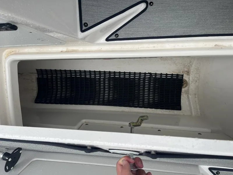 Slide: The Image of 2023 Yamaha AR250 boat storage compartment with black mesh lining. - 20
