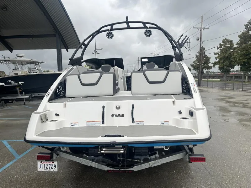 Slide: The Image of 2023 Yamaha AR250 boat on trailer, rear view, in a parking area. - 3