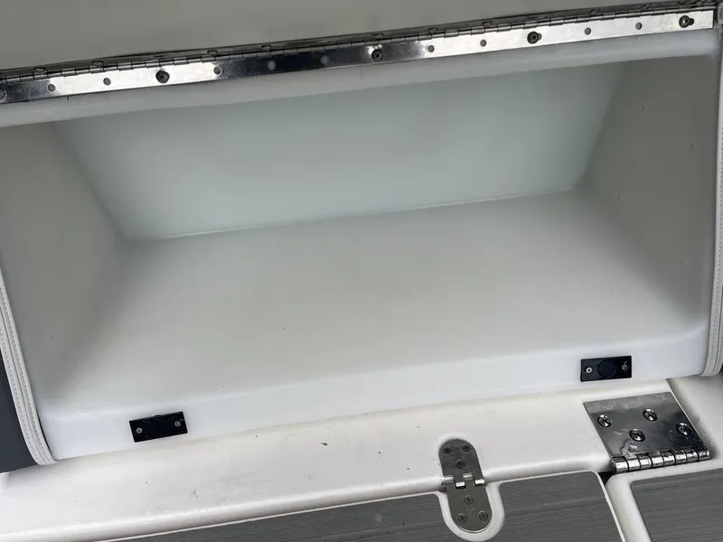 Slide: The Image of 2023 Yamaha AR250 boat storage compartment with metal hinges. - 6