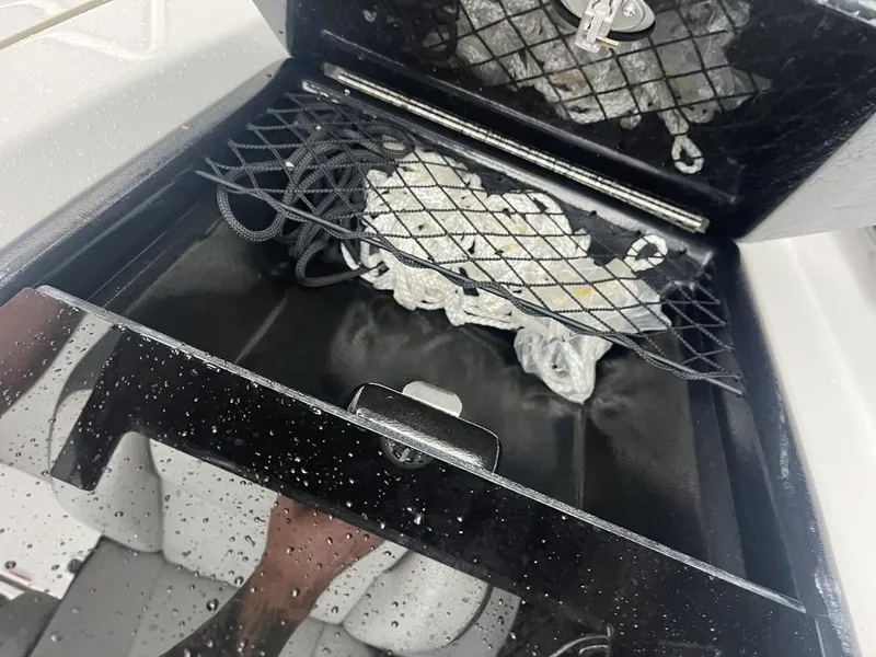 Slide: The Image of Yamaha AR250 2023 boat storage compartment with netting and rope. - 8