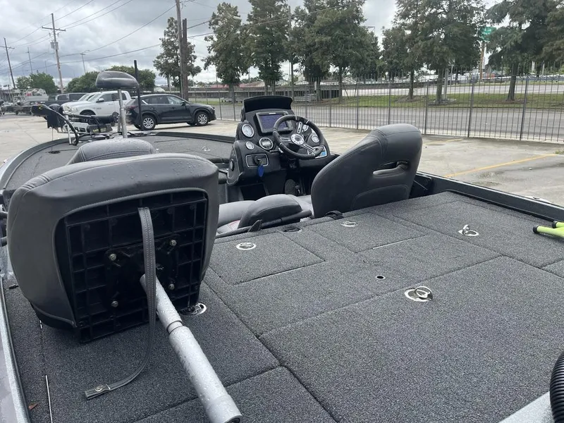 Slide: The Image of 2017 Nitro Z21 boat interior with steering console and seating in a parking lot. - 9