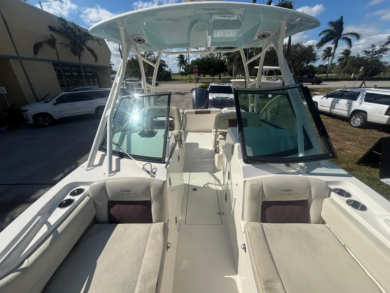 Slide: The Image of 2021 Cobia 240 Dual Console boat with open seating and clear skies. - 13