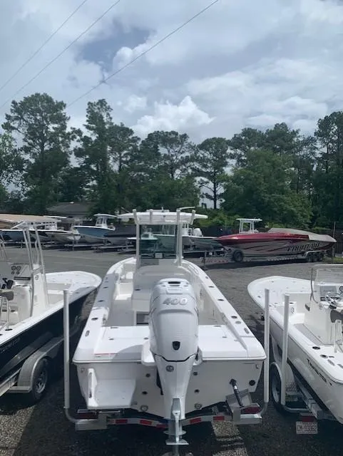 Slide: The Image of 2021 Everglades 253 Center Console boat in a marina, surrounded by trees. - 2