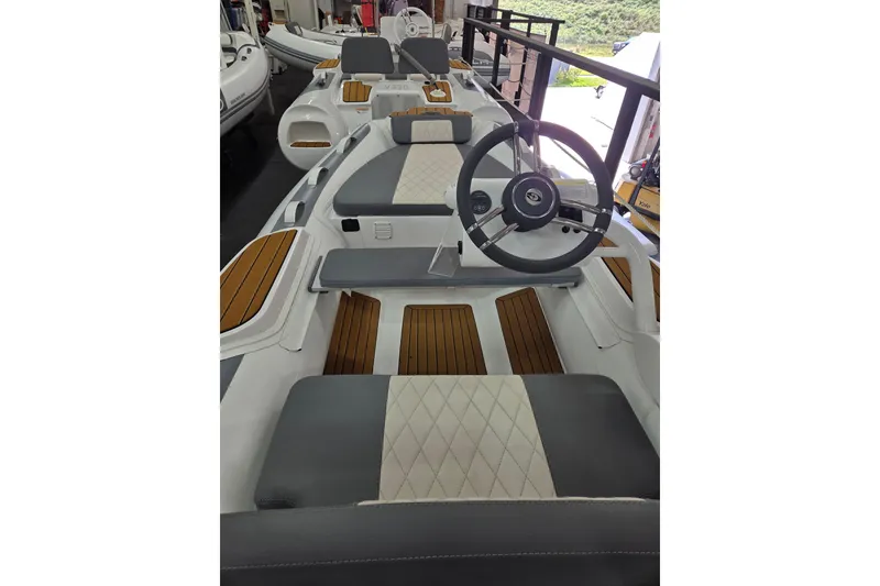 Slide: The Image of 2025 Gala A360HQ ELECTRIC boat interior with steering wheel and cushioned seating. - 5