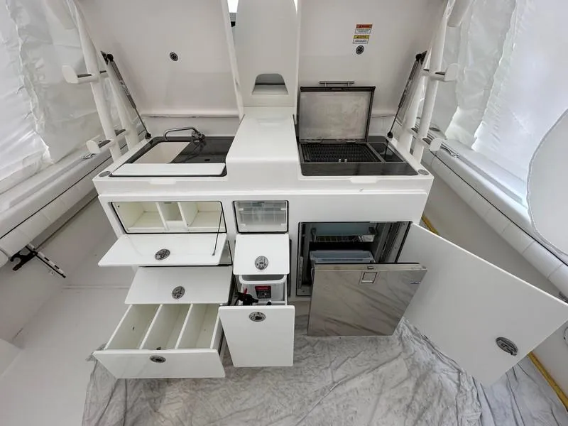 Slide: The Image of 2016 Regulator 41 boat kitchen with open storage, grill, and sink. - 24