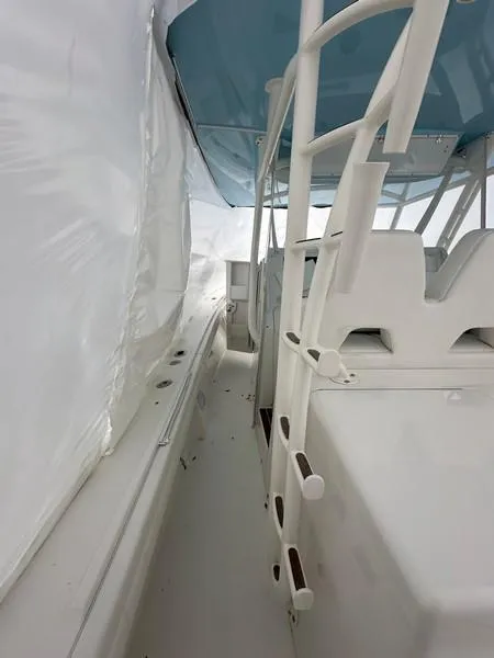 Slide: The Image of 2016 Regulator 41 boat interior with ladder and seating under blue canopy. - 25