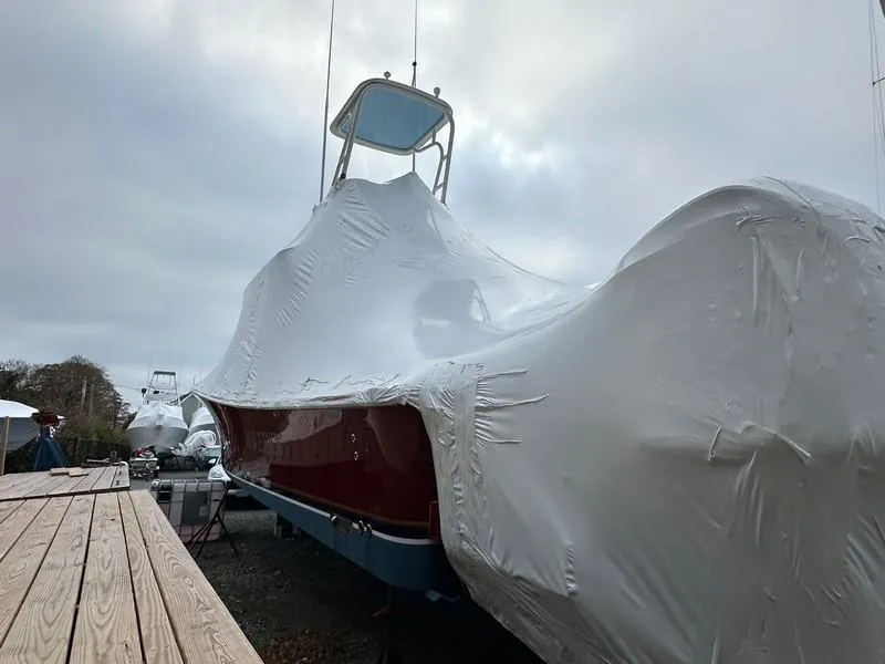Slide: The Image of 2016 Regulator 41 boat covered in protective wrap, docked outdoors. - 7