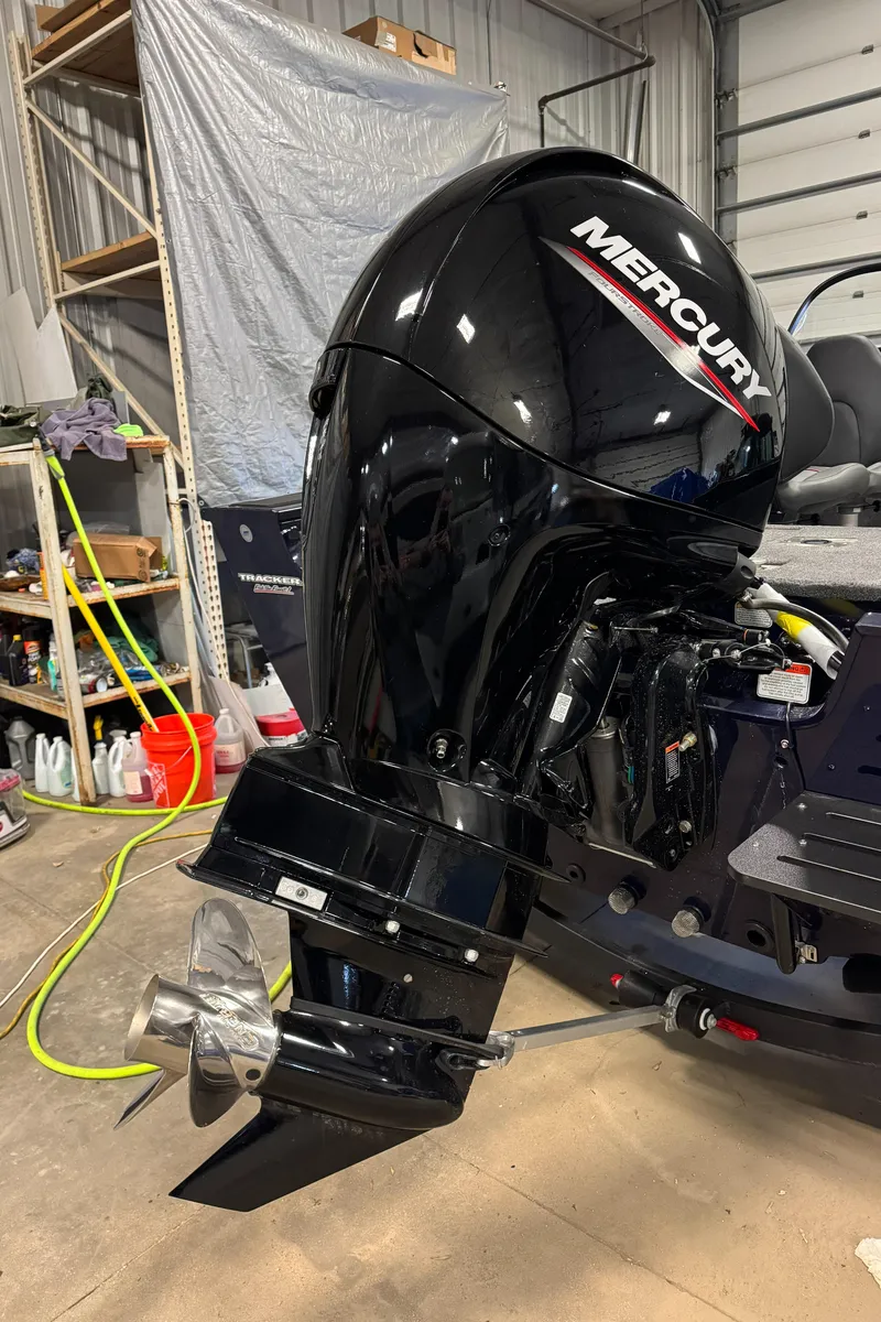 Slide: The Image of 2025 Tracker TARGA V18WT with Mercury outboard motor in a garage setting. - 5