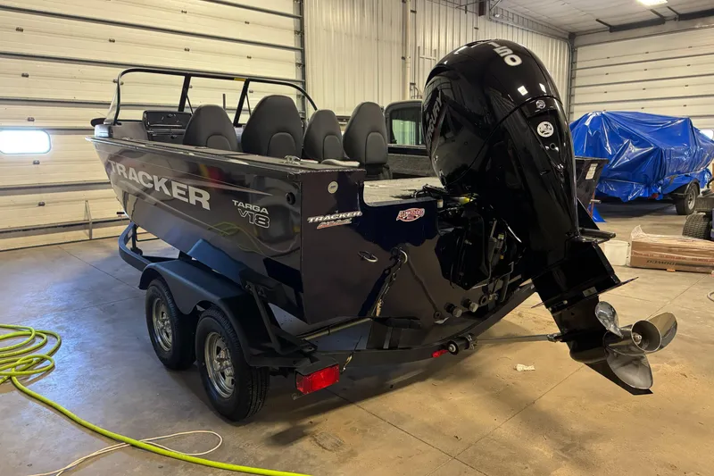 Slide: The Image of 2025 Tracker TARGA V18WT boat in garage, featuring powerful outboard motor. - 3
