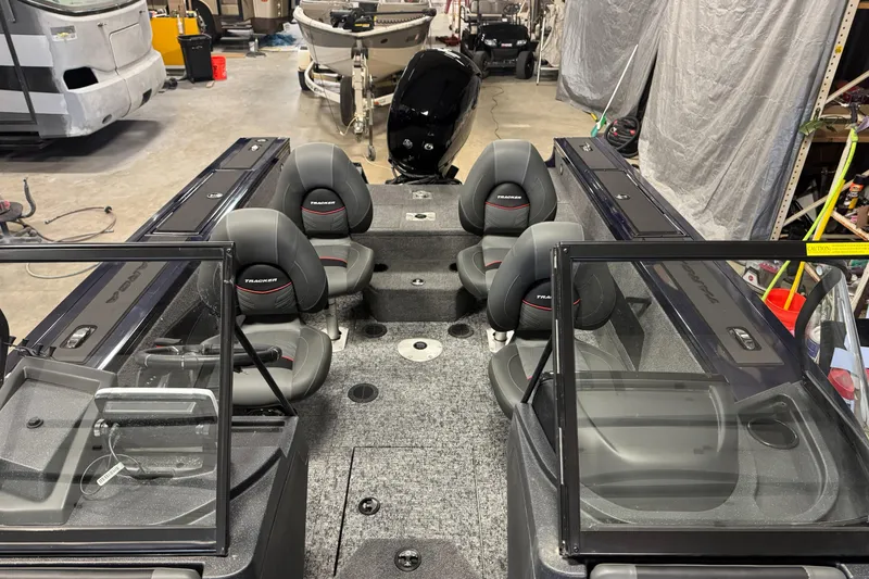 Slide: The Image of 2025 Tracker TARGA V18WT boat interior with four seats in a garage setting. - 7