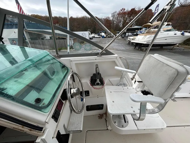 Slide: The Image of 1996 Robalo 2440 Walkaround boat cockpit with steering wheel and captain's chair. - 14