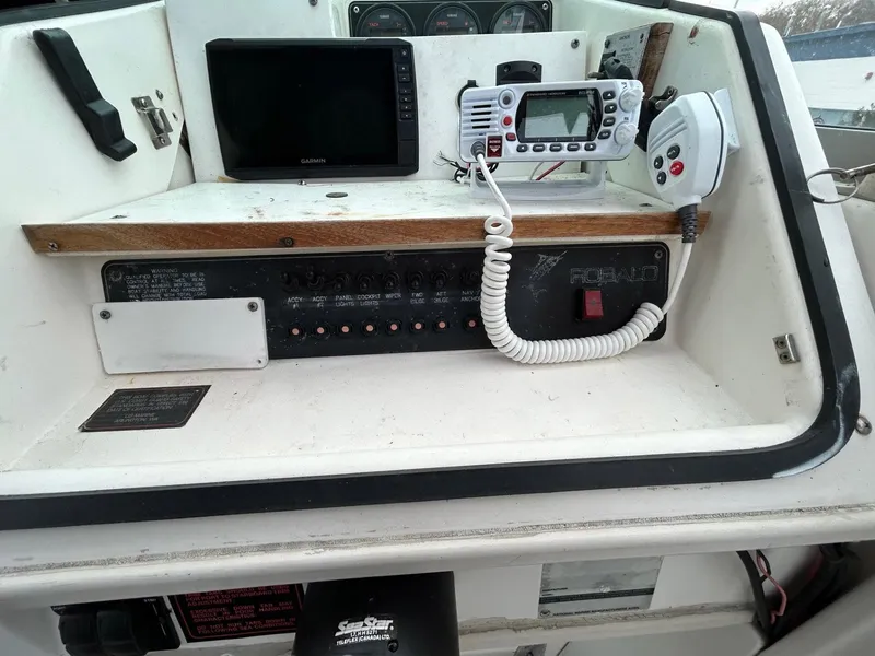 Slide: The Image of 1996 Robalo 2440 Walkaround boat dashboard with radio and navigation equipment. - 16