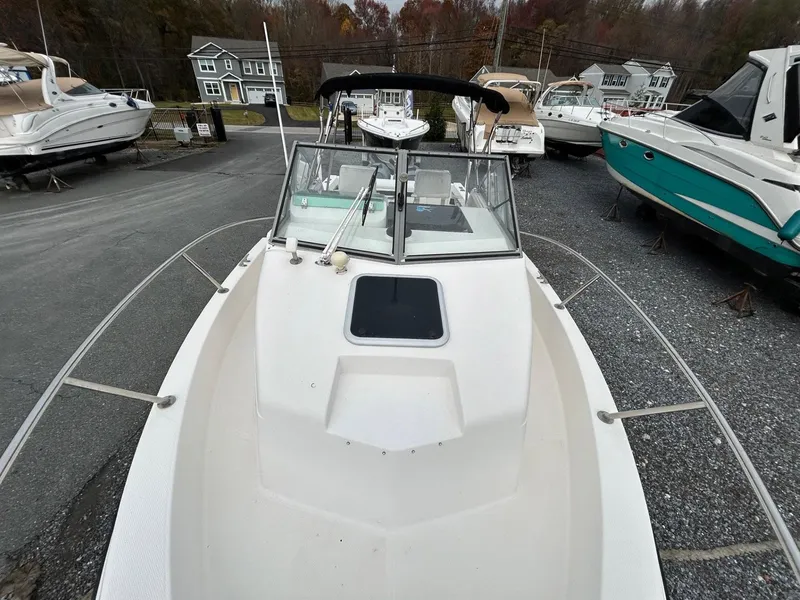 Slide: The Image of 1996 Robalo 2440 Walkaround boat on display in a marina with other vessels. - 22