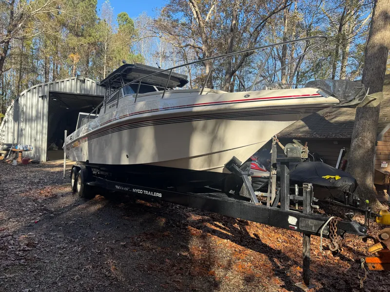 Slide: The Image of 1996 Fountain 32 Sportfish Cruiser IO on trailer in wooded area. - 0